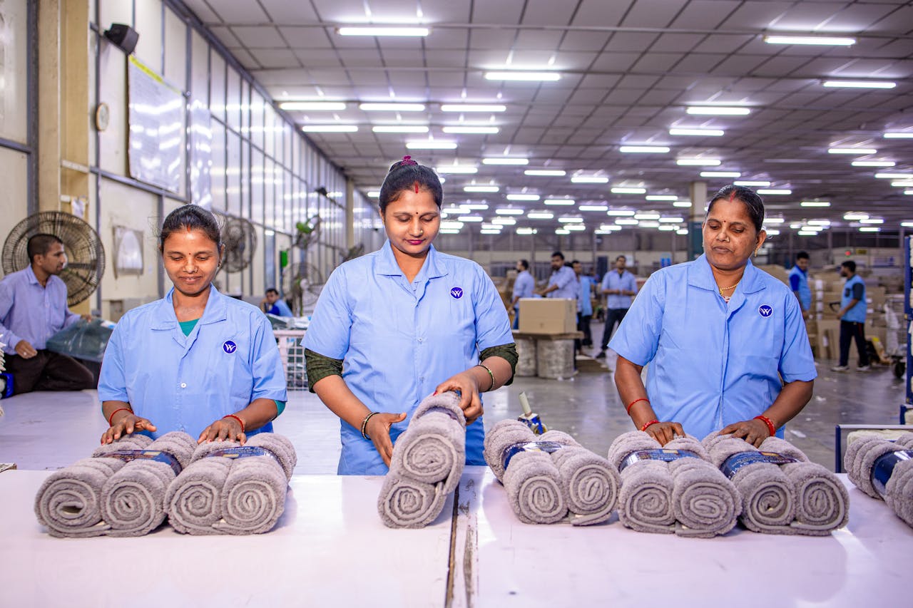 Crafting Captivating Headlines: Your awesome post title goes here Three female workers inspecting rolled towels at a textile factory, showcasing teamwork and quality control.