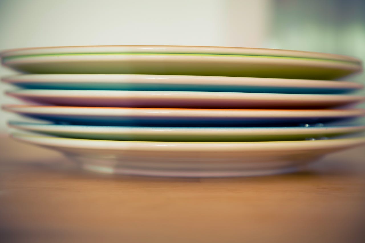 Artistic close-up of colorful stacked plates with a smooth bokeh background.